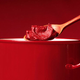 spoon of tomato paste hovering above a red cooking pot